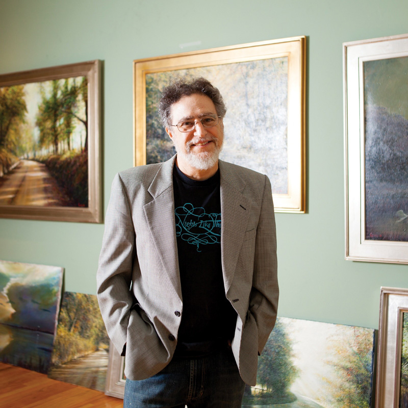 Dean Gioia A man standing in front of some paintings.